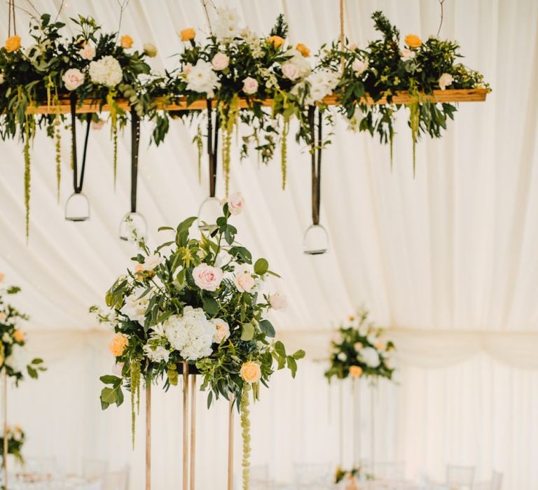 Marquee decor with floral installations and hanging stirrup displays