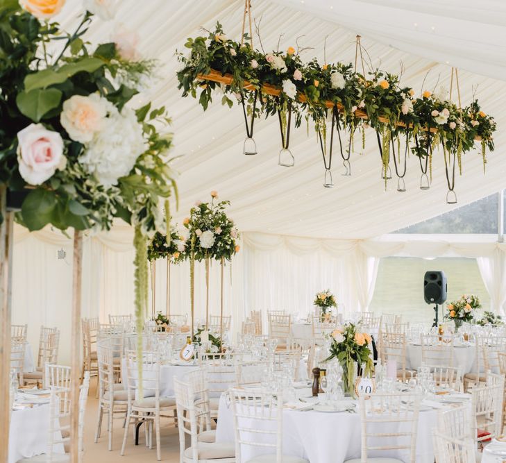 Marquee decor with floral installations and hanging stirrup displays