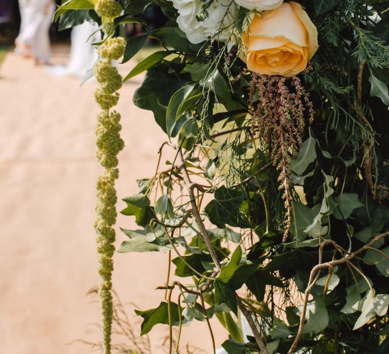 Details of flower arch with peach and pink rose floral touches at Wales wedding venue