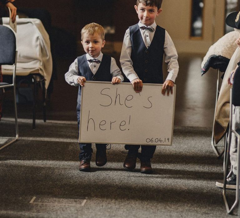 page boys with 'She's Here' sign