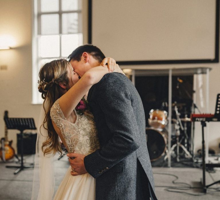 Bride and groom kissing at the altar