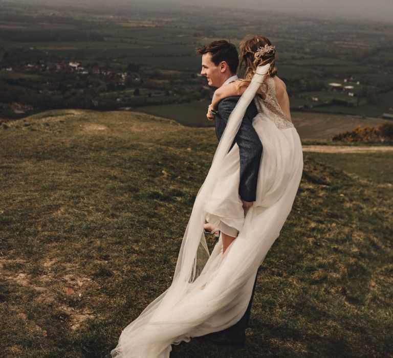 bride on her grooms back in the countryside