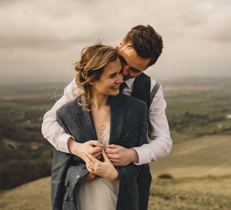 groom wrapping his bride in a jacket to keep her warm