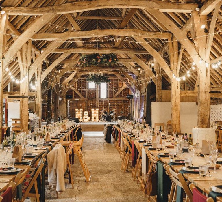 Rustic barn wedding reception with string lights and colourful flowers