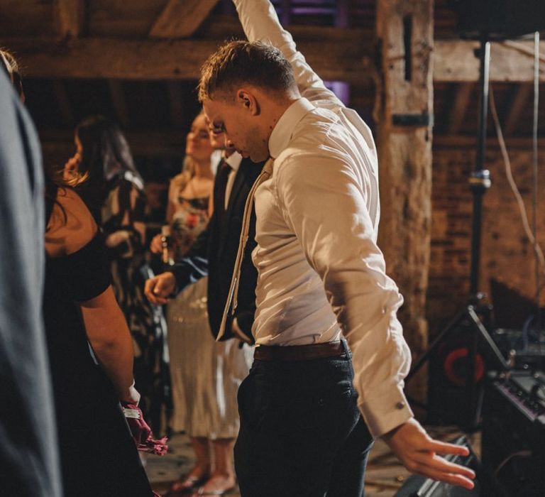 Wedding guests dancing at the rustic barn evening reception