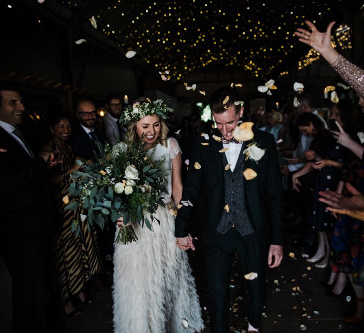 Confetti Moment with Bride in Halfpenny London Swan Tulle Petal Skirt and Flower Crown and Groom in Wool Suit and Bow Tie