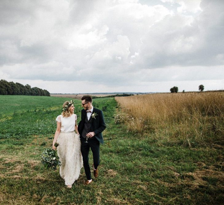 Bride in Halfpenny London Swan Tulle Petal Skirt and Flower Crown and Groom in Wool Suit &amp; Bow Tie Hand in Hand