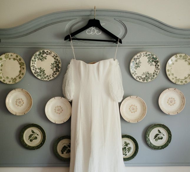 Wedding dress hung up over vintage plates