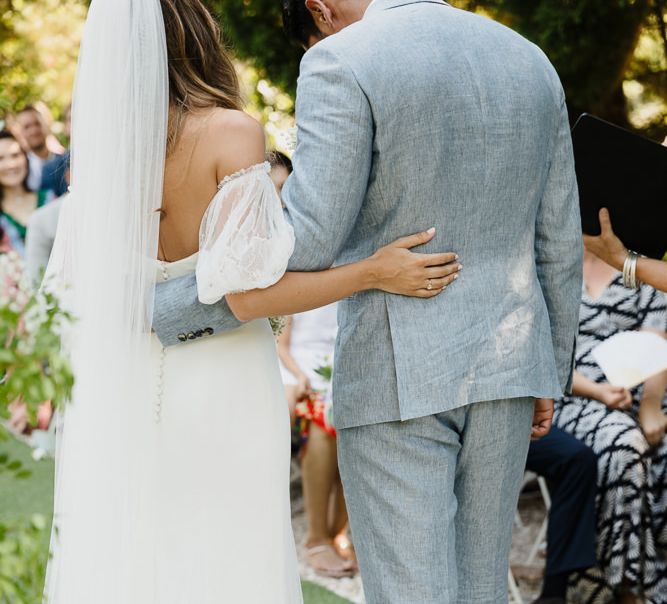 Bride and groom from the back. Bride wearing off the shoulder wedding dress