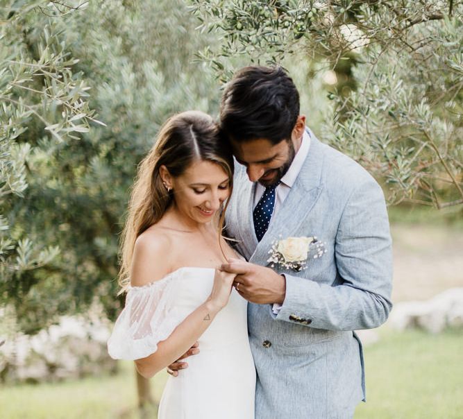 Bride in off the shoulder dress made by the bride and her team at Halfpenny London and groom in blue suit from Reiss