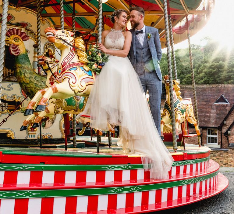 Carousel Ride | Bride in Halterneck Tulle Allure Bridal Wedding Dress | Groom in  Blue Check Moss Bros. Suit | Vintage Fairground at Blists Hill Victorian Town Museum in Ironbridge | Lisa Carpenter Photographer