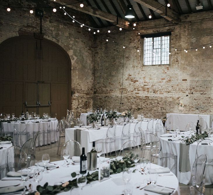 Elegant Wedding Reception Decor with Festoon Lights and Ghost Chairs