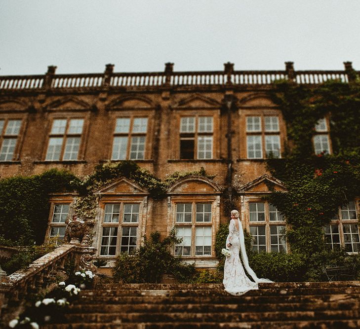 Bride in Vintage Lace Tara Lauren Wedding Dress and Groom in Black Tie Suit Standing Front of Brympton House Wedding Venue