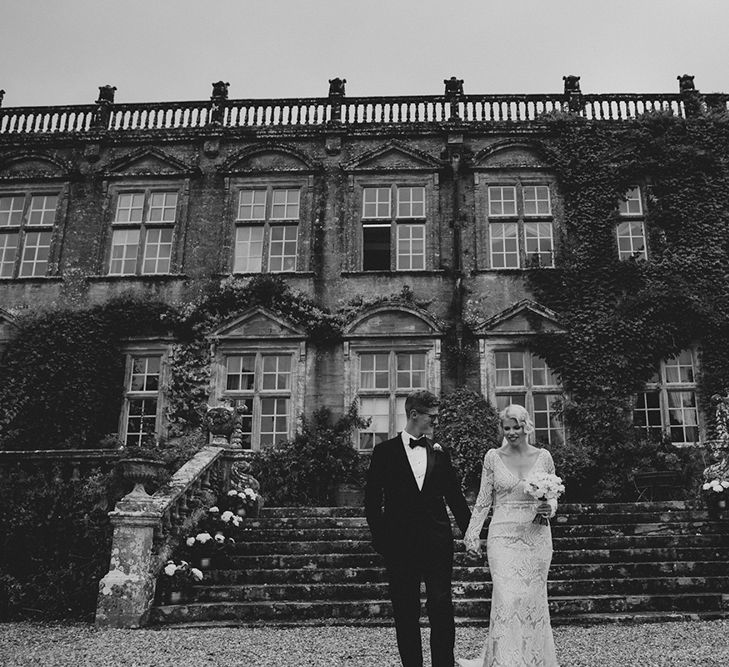 Bride in Vintage Lace Tara Lauren Wedding Dress and Groom in Black Tie Suit Standing Front of Brympton House Wedding Venue