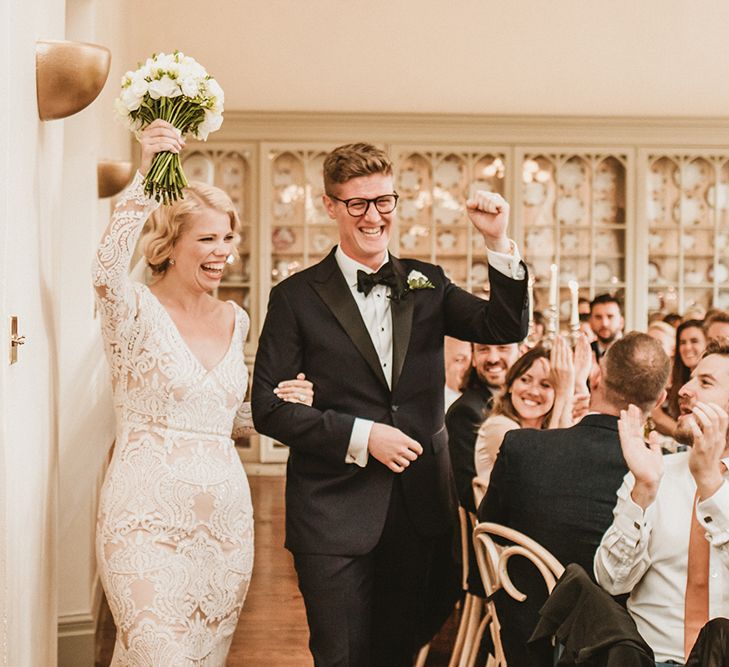 Bride in Vintage Lace Tara Lauren Wedding Dress and Groom in Tuxedo Entering Wedding Breakfast