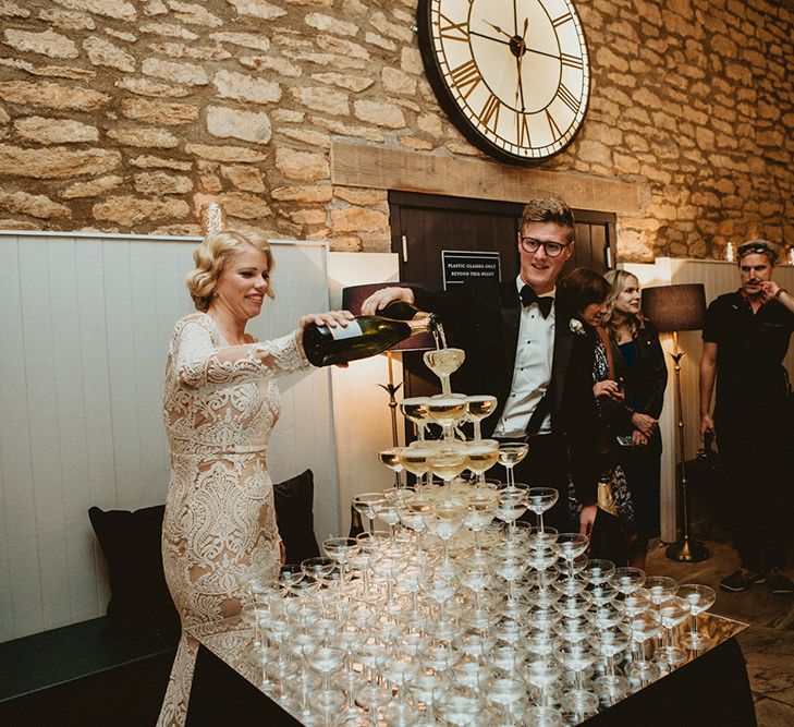 Bride in Vintage Lace Tara Lauren Wedding Dress and Groom in Tuxedo Filling Champagne Tower