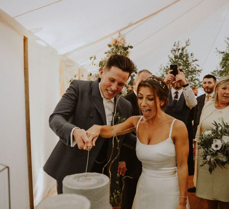 Bride and groom cut the wedding cake at Lulworth Castle wedding