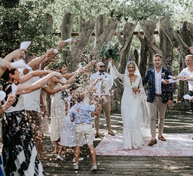 Confetti Moment | Bride in Spell &amp; the Gypsy Collective Bell Sleeve Wedding Dress | Groom in Chino's &amp; Blazer | Outdoor Bohemian Destination Wedding at La Selva, Tuscany | Damien Milan Photography