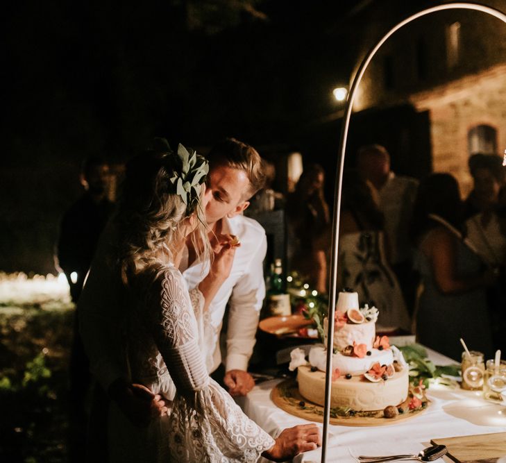 Cutting the Cake | Bride in Spell &amp; the Gypsy Collective Bell Sleeve Wedding Dress | Groom in Chino's &amp; Blazer | Outdoor Bohemian Destination Wedding at La Selva, Tuscany | Damien Milan Photography