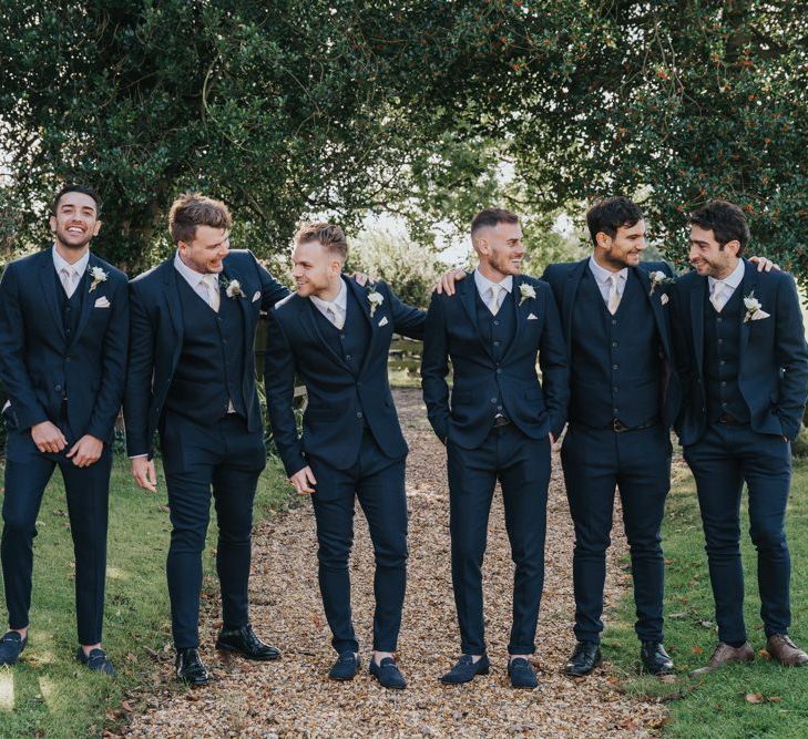 Groom and groomsmen in matching navy suits