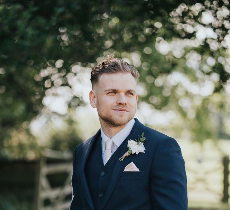 Groom in navy blue three piece suit