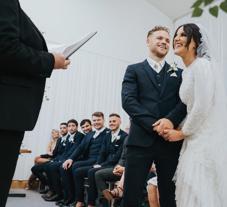 Bride in bespoke Emma Beaumont wedding dress with ruffle hem veil