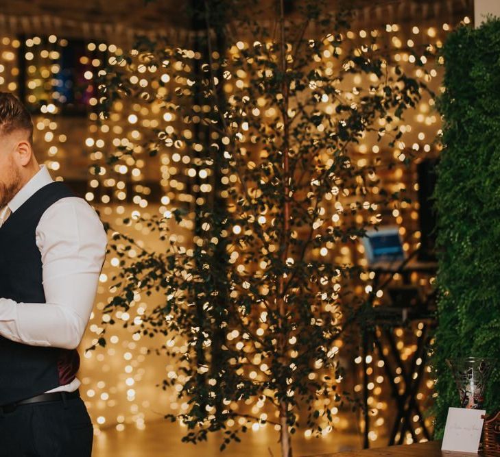 Groom makes wedding speech with fairy light backdrop