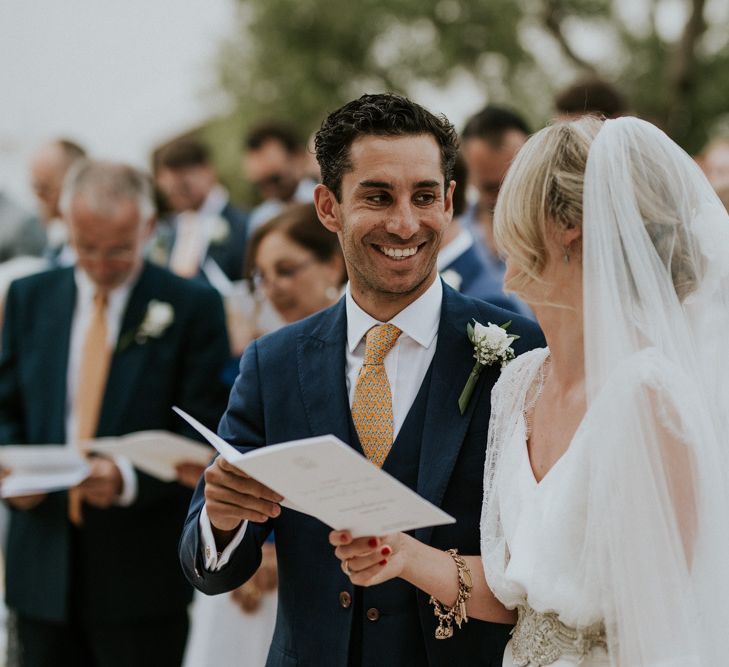 Outdoor Wedding Ceremony with Bride in Halfpenny Wedding Dress  and Groom in Navy Blue Suit