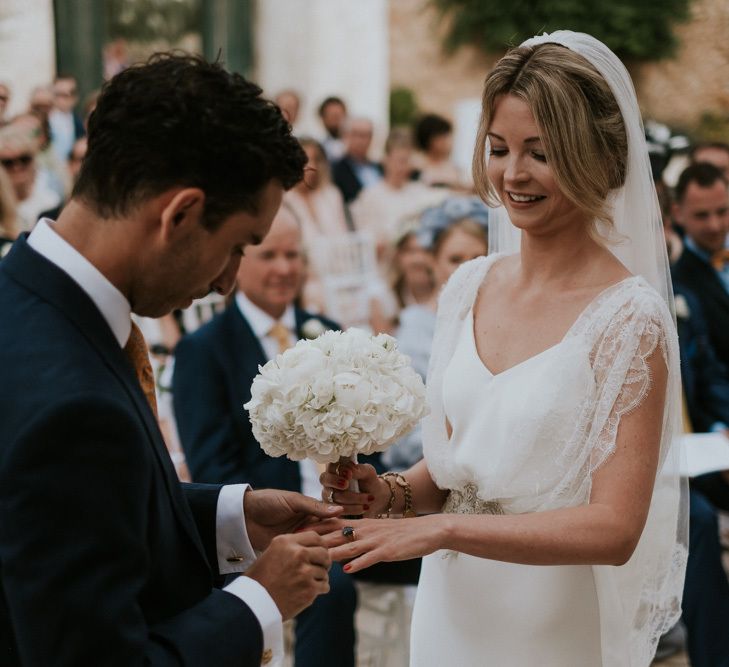 Outdoor Wedding Ceremony with Groom Putting On His Bride in Halfpenny Wedding Dress Wedding Ring