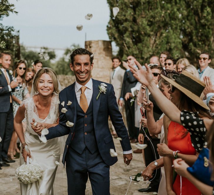 Confetti Moment with Bride in Halfpenny Wedding Dress and Groom in Navy Suit