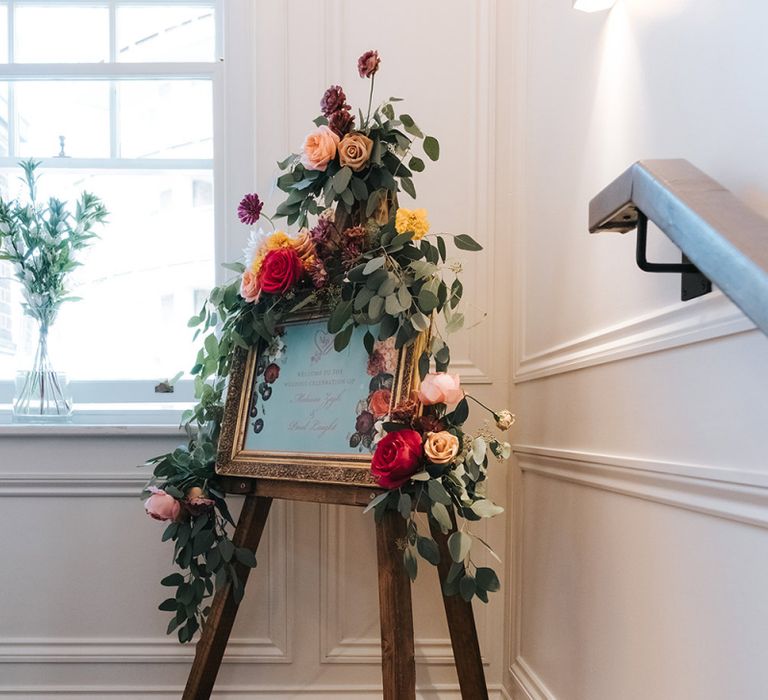 Wedding Welcome Sign in Gold Frame | Wooden Easel | Eucalyptus Garland with Colourful Flowers | Meringue Kisses &amp; Colourful Wedding Flowers &amp; Stationery for a London Wedding at The Globe | Miss Gen