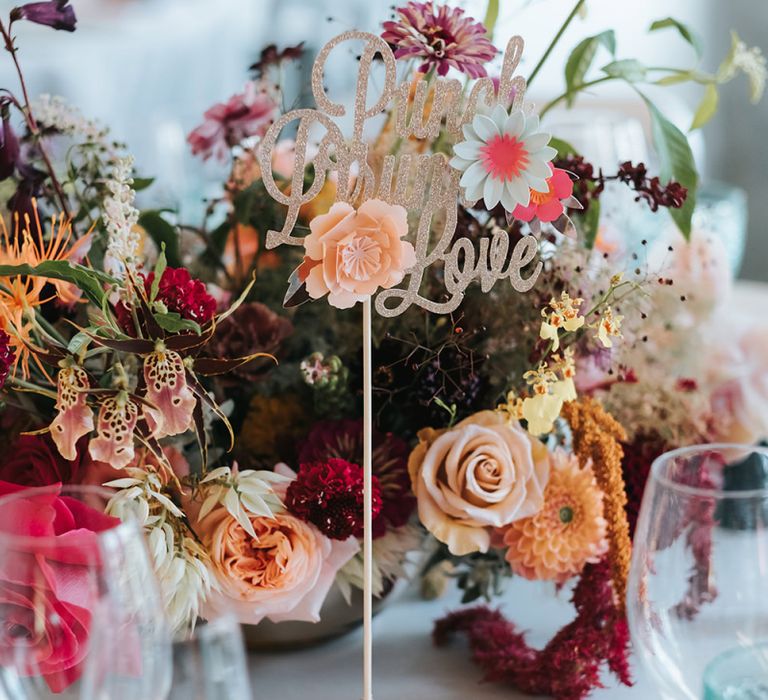 Sparkly Gold Table Sign | Colourful Floral Centrepiece | Tea Light Holder with Gold Glitter Detail | Blue Wine Glasses | Meringue Kisses &amp; Colourful Wedding Flowers &amp; Stationery for a London Wedding at The Globe | Miss Gen