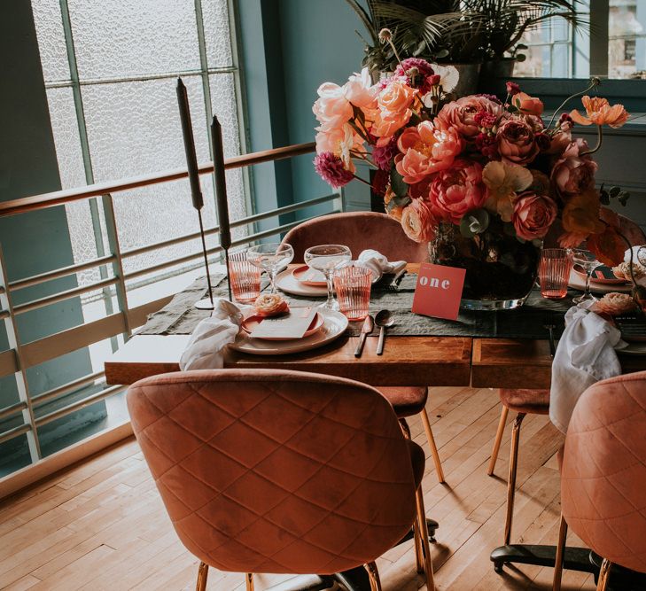 Living Coral Retro Table Decor with Floral Centrepiece , Velvet Chairs,  and Candle Sticks