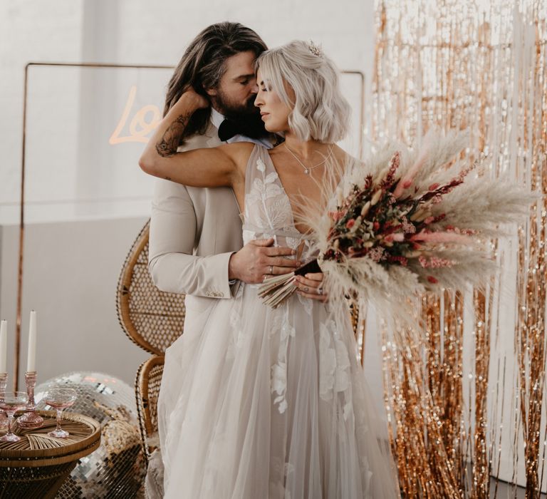 Boho bride and groom wedding portrait with oversized bouquet