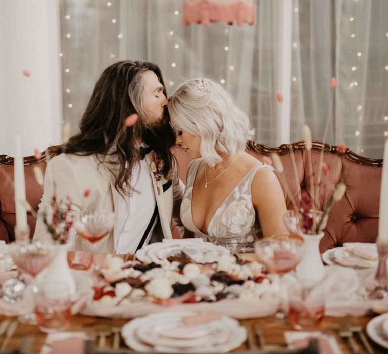 Contemporary bride and groom sitting at the reception table