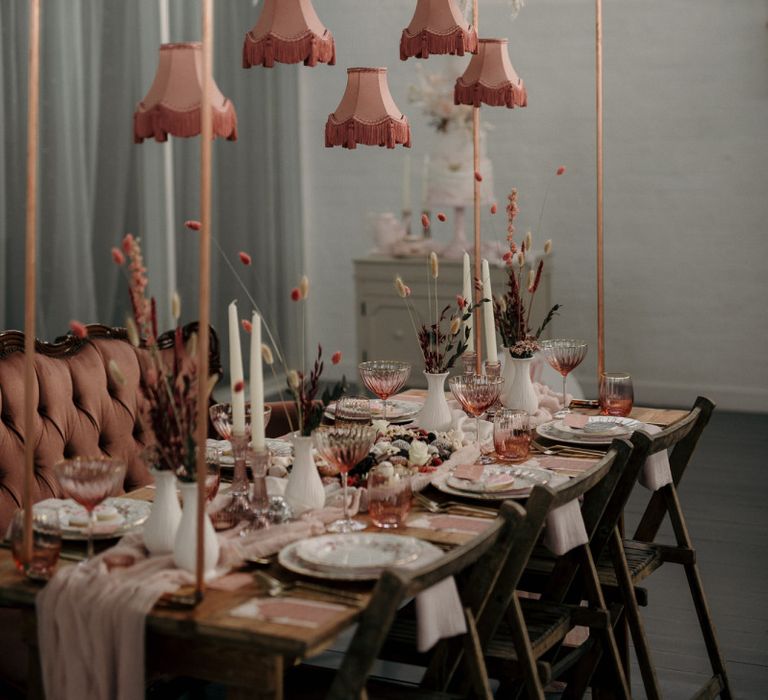 Romantic blush pink wedding reception table decor with hanging flower and lampshade installation