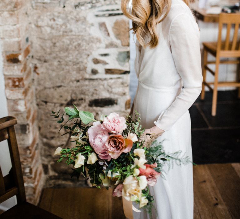 Bride in Andrea Hawkes Wedding Dress with Long Sleeves and Wavy Hair