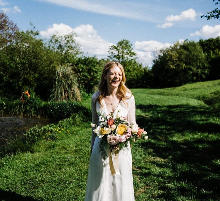 Beautiful Bride in Andrea Hawkes Wedding Dress Holding a Spring Bouquet