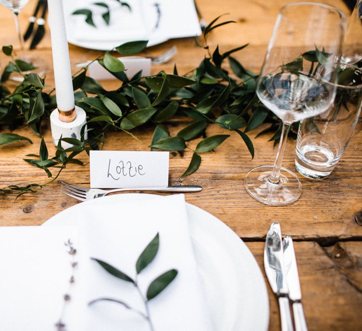 Place Setting with Greenery Runner and White Candles