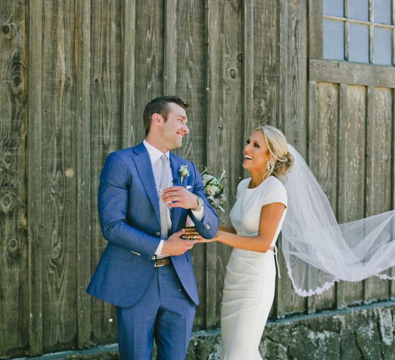 Groom in Blue Suit Supply Suit Turning Around to Greet His Bride  During First Look