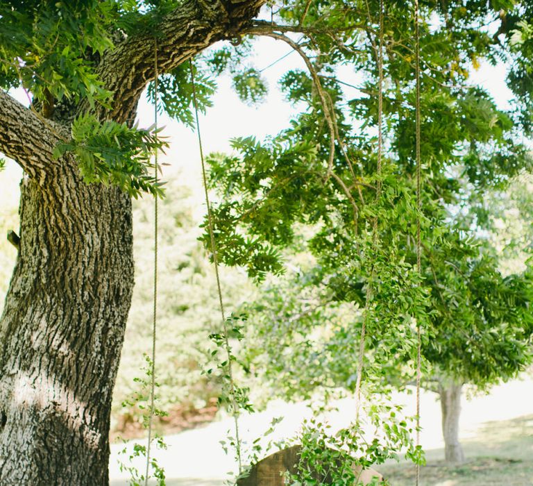 Hanging Wooden Swing Decorated with Foliage