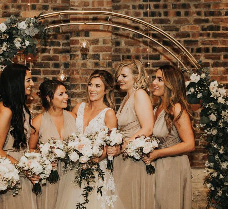 Bride in Enzoani dress with bridal party in nude bridesmaid dresses