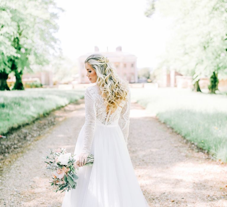 Bride in Lace Wedding Dress Holding White Peony and Peach David Austin Rose Wedding Bouquet and Half up Half Down Wavy Hairstyle