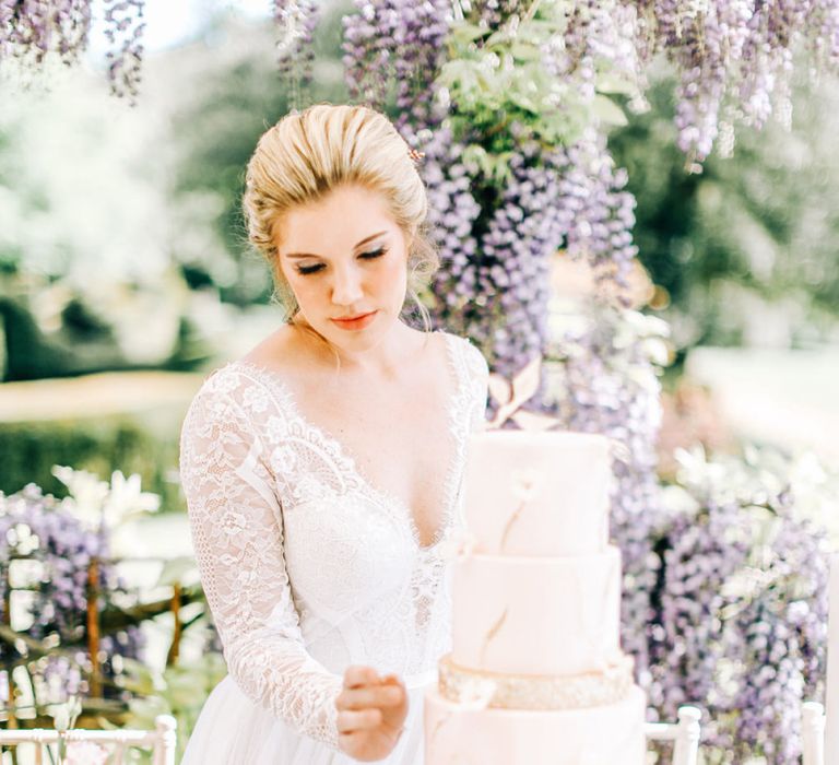 Bride Looking at Marble Effect Wedding Cake with Gold Glitter Layer