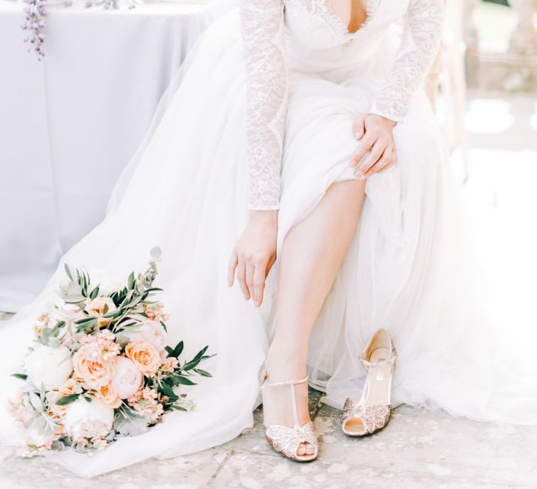 Bride in Lace Wedding Dress putting On Sequin T Bar  Bridal Shoes