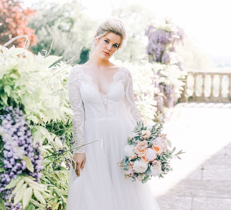 Bride in Lace and Tulle Wedding Dress Holding a Peach and White Wedding Bouquet