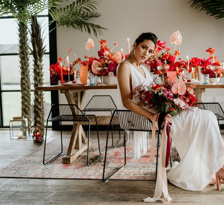 Stylish Bride in Modern Wedding Dress with Pink Bridal Boots holding a Tropical Bridal Bouquet with Anthurium Flower Stems