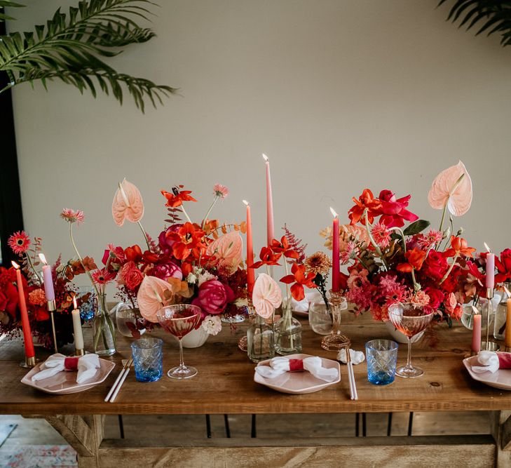 Wedding Table Decor with Red and Pink Floral Centrepiece Flowers with Anthurium Flower Stems, Taper Candles and Coloured Glasses