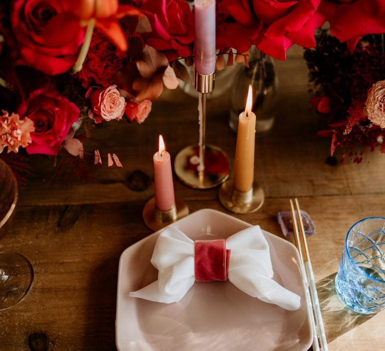 Place Setting with Pink Plate,  Bow Napkin, Taper Candles and Floral Centrepiece