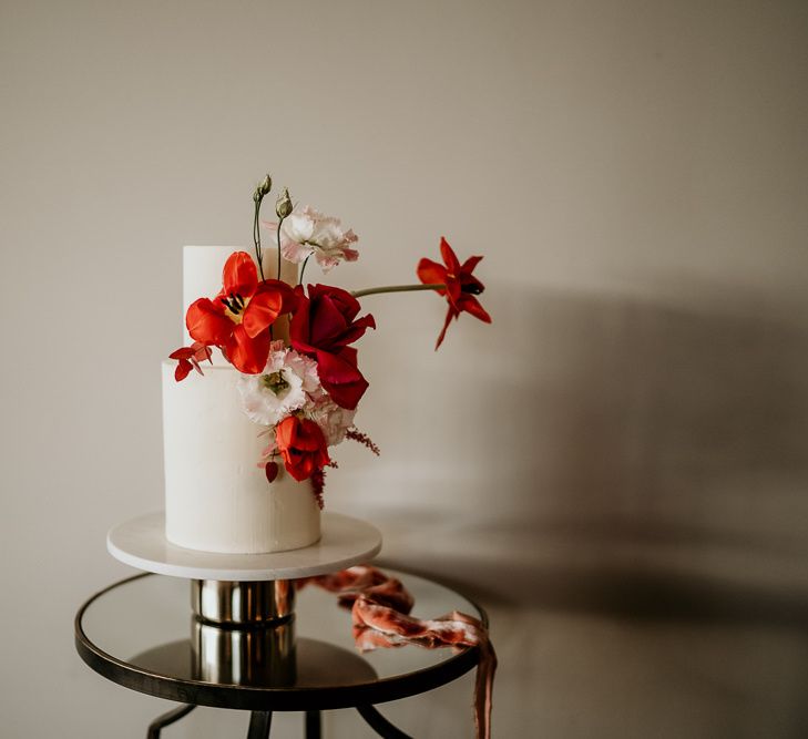 Two Tier Minimalist White Wedding Cake Decorated with Red Wedding Flowers